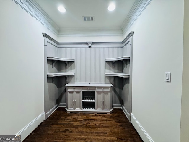 unfurnished office featuring dark wood-style floors, baseboards, visible vents, and ornamental molding