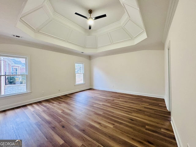 spare room with dark wood finished floors, crown molding, visible vents, a ceiling fan, and baseboards