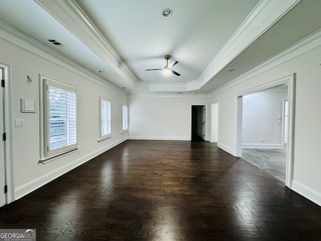 unfurnished room with baseboards, visible vents, a raised ceiling, ornamental molding, and wood finished floors