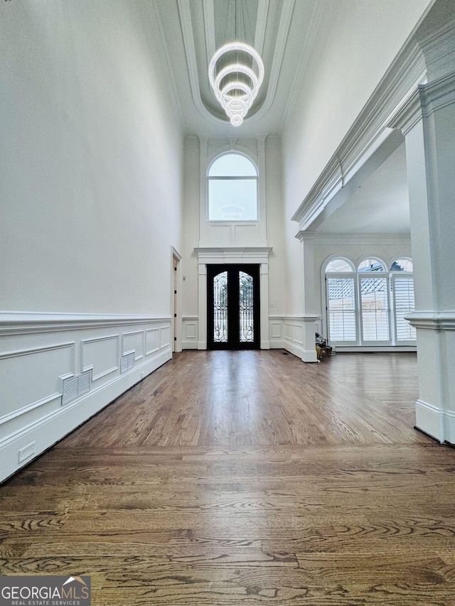 entryway featuring crown molding, plenty of natural light, french doors, and a notable chandelier