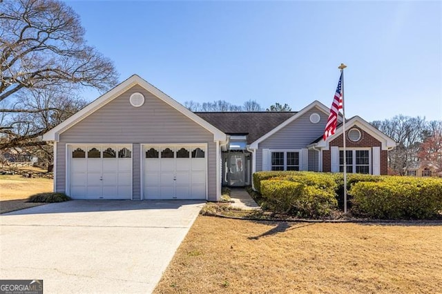 view of front of property with a garage, concrete driveway, and brick siding