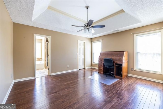 unfurnished living room with a textured ceiling, a tray ceiling, and dark wood-type flooring