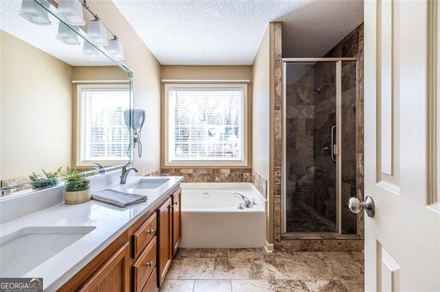 bathroom with plenty of natural light, a garden tub, a sink, and double vanity