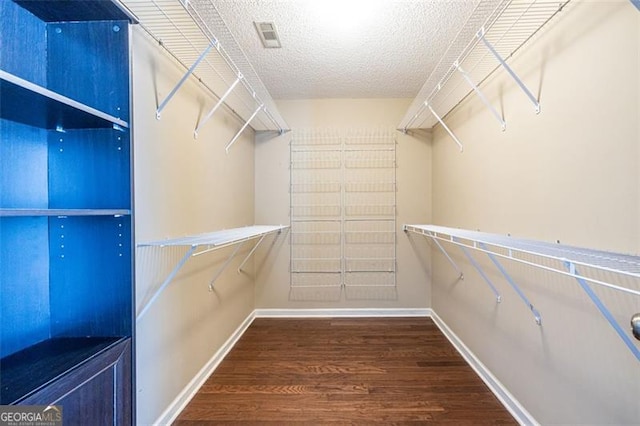 walk in closet with wood finished floors