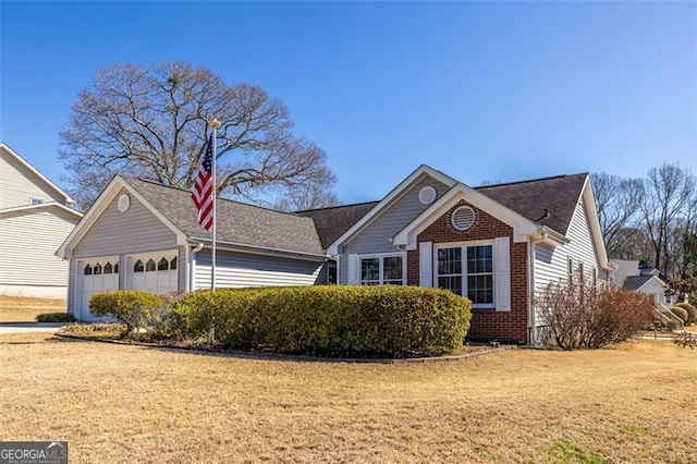 single story home with an attached garage, a front lawn, and brick siding