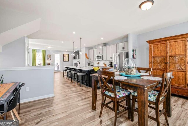 dining room with light wood-style flooring, baseboards, and recessed lighting