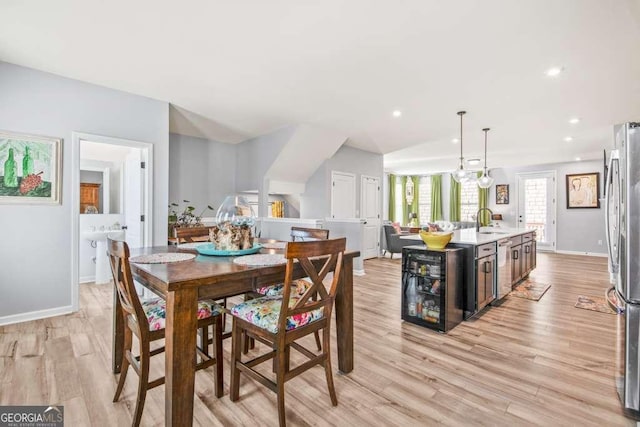 dining room featuring beverage cooler, recessed lighting, light wood-type flooring, and baseboards