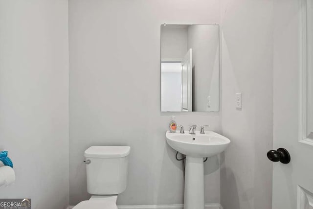 bathroom featuring toilet and baseboards