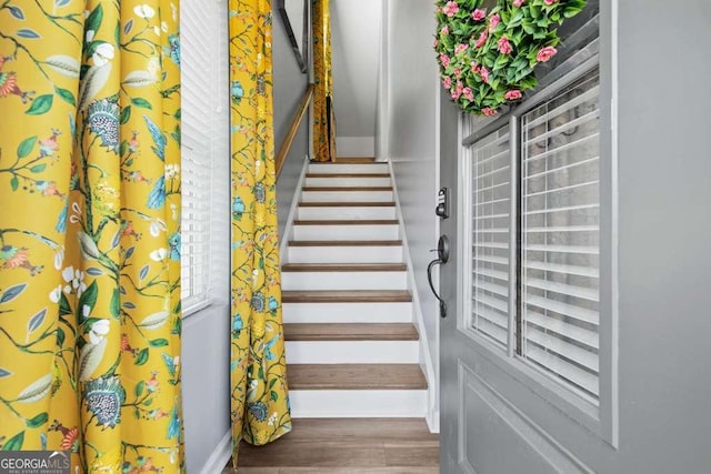 staircase with baseboards and wood finished floors