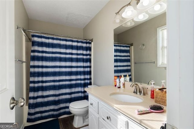 full bath with a shower with curtain, vanity, toilet, and a textured ceiling