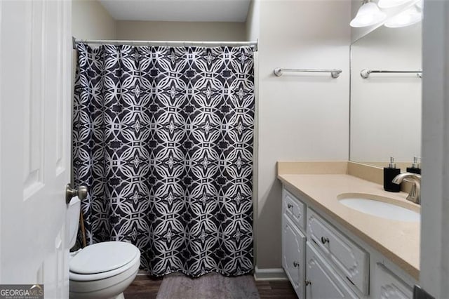 bathroom with curtained shower, vanity, toilet, and wood finished floors