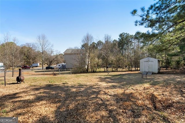 view of yard with a storage shed, an outdoor structure, and fence