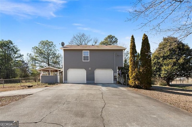 view of property exterior featuring an attached garage, fence, and concrete driveway