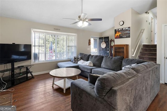 living area featuring dark wood-style floors, vaulted ceiling, ceiling fan, baseboards, and stairs