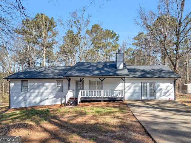 view of front of home featuring covered porch, crawl space, and a chimney