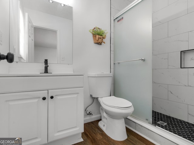 full bathroom featuring toilet, a shower stall, wood finished floors, and vanity