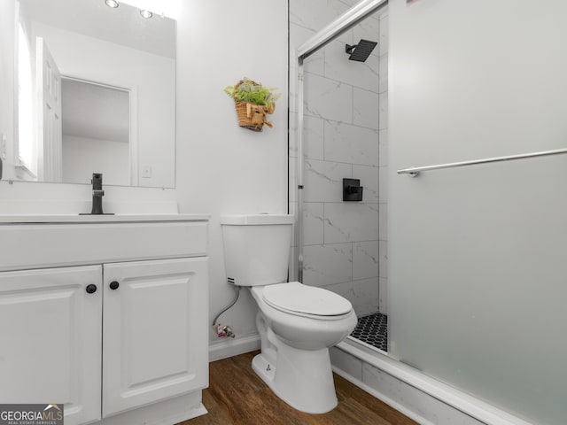 bathroom featuring a shower stall, vanity, toilet, and wood finished floors