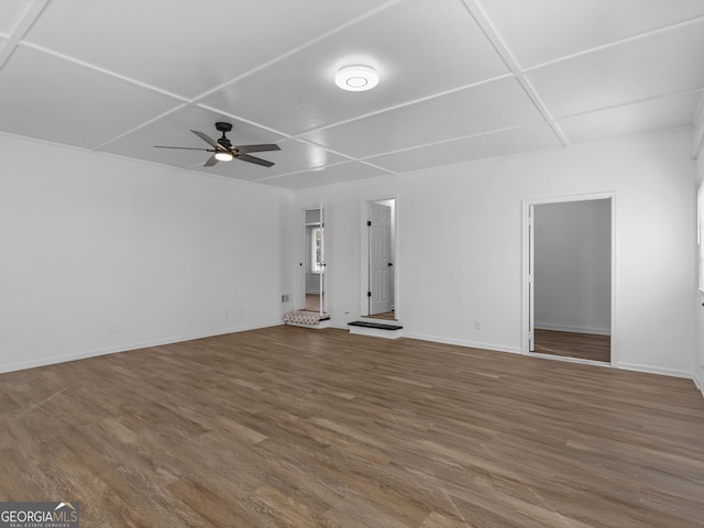 unfurnished living room with ceiling fan, baseboards, and wood finished floors