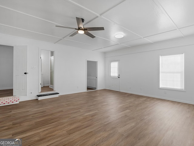 unfurnished living room featuring ceiling fan, baseboards, and wood finished floors