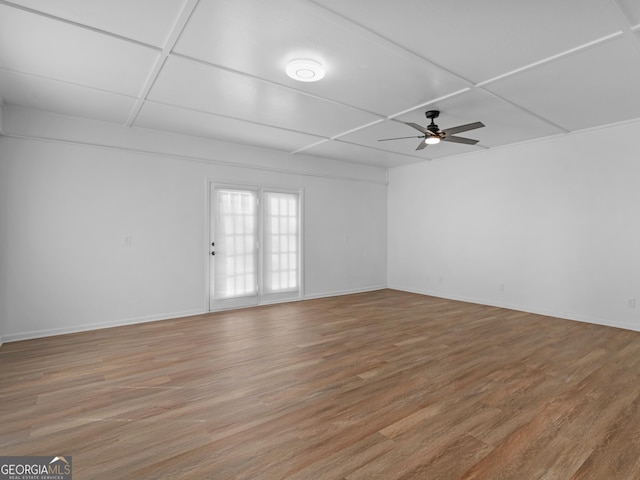 spare room featuring light wood-style floors, baseboards, and a ceiling fan