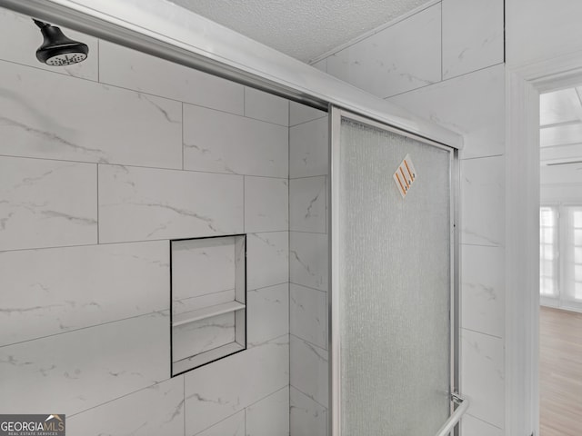 interior space with a tile shower and wood finished floors