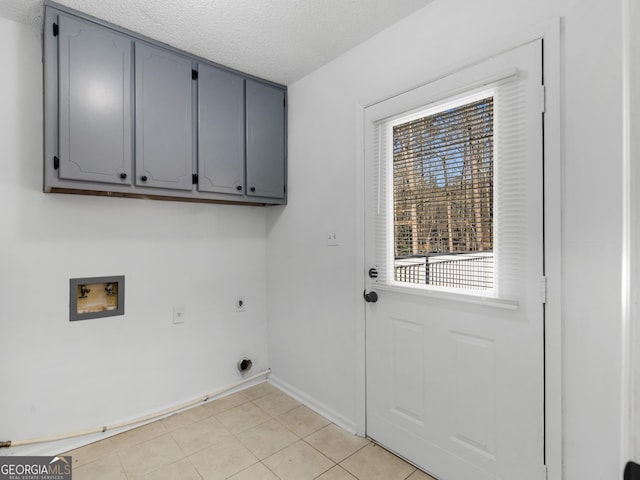 clothes washing area featuring cabinet space, baseboards, a textured ceiling, hookup for an electric dryer, and washer hookup