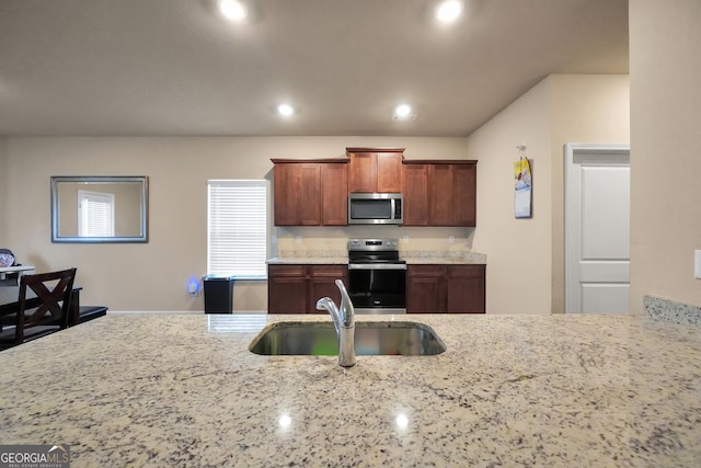 kitchen featuring appliances with stainless steel finishes, recessed lighting, a sink, and light stone countertops