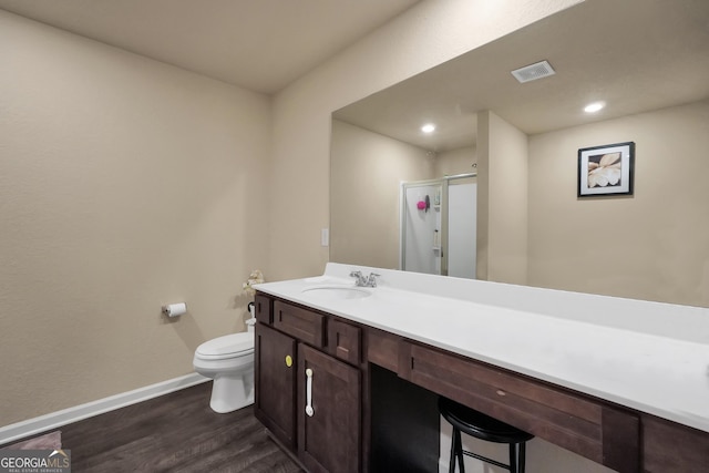 bathroom featuring baseboards, visible vents, toilet, wood finished floors, and vanity