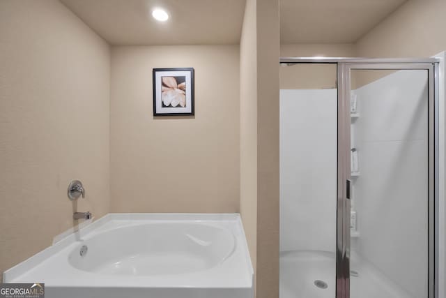 bathroom featuring a garden tub and a shower stall