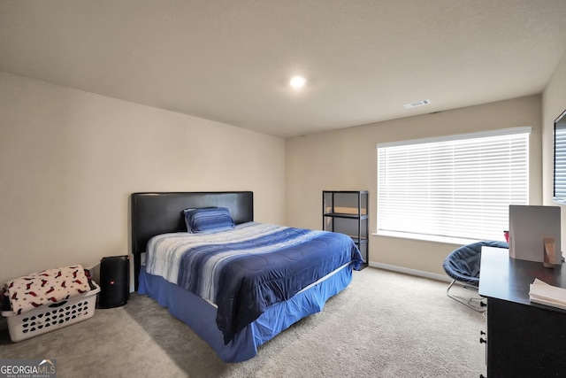 bedroom featuring baseboards, visible vents, and light colored carpet