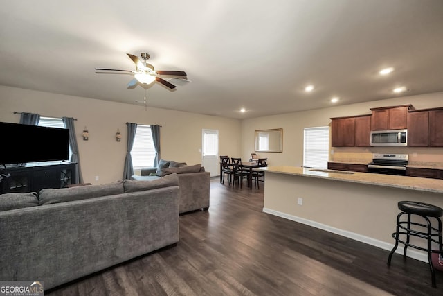 living room with dark wood-style floors, baseboards, a ceiling fan, and recessed lighting