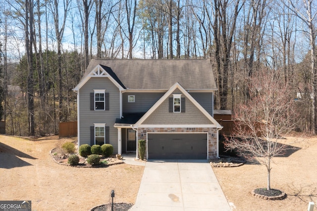 view of front of house with a garage, stone siding, and driveway