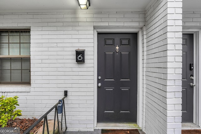 entrance to property featuring brick siding