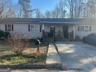 ranch-style house featuring covered porch and concrete driveway