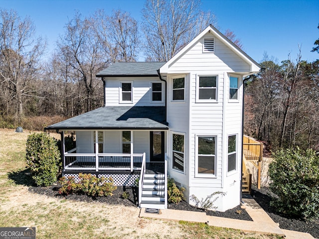 traditional-style home with covered porch and a front lawn