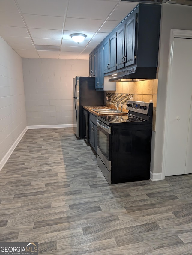 kitchen featuring a sink, stainless steel range with electric stovetop, blue cabinetry, and light wood-style floors