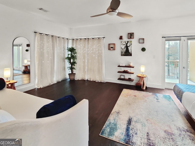 interior space with access to exterior, visible vents, ceiling fan, and wood finished floors