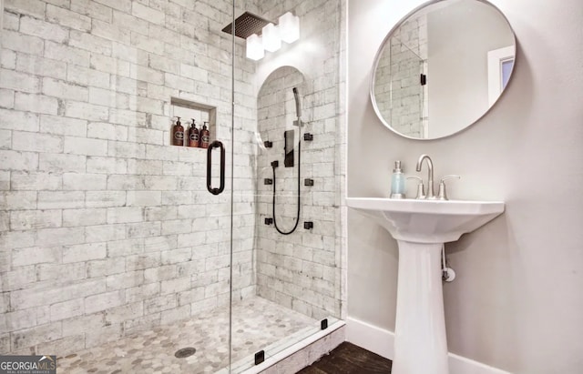 full bathroom with a shower stall and baseboards