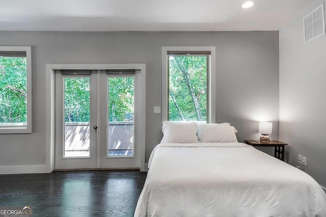 bedroom featuring dark wood-style floors, access to outside, multiple windows, and visible vents