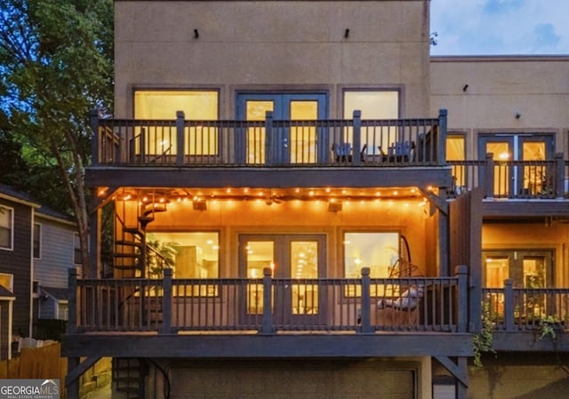 back of house with a balcony and stucco siding