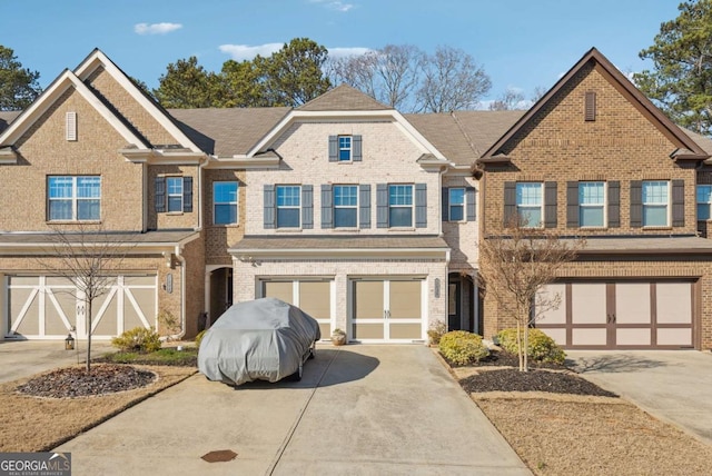 multi unit property featuring a garage, driveway, and brick siding