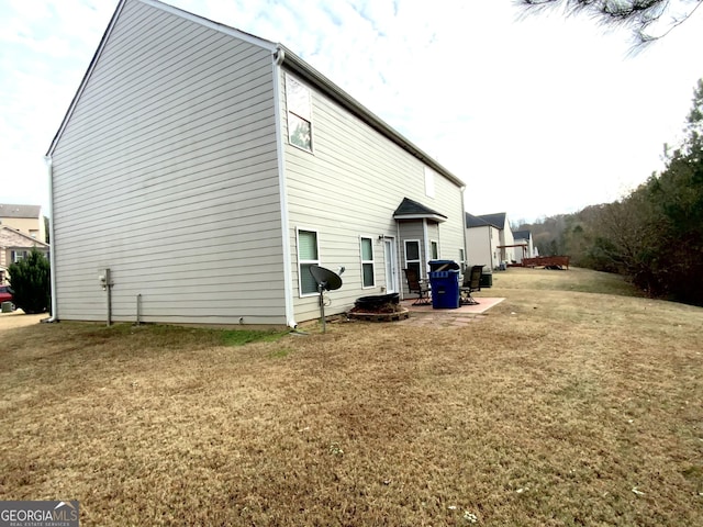 view of side of property featuring a patio area and a lawn