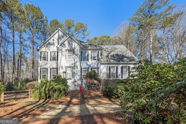 view of front of house with a shingled roof and fence