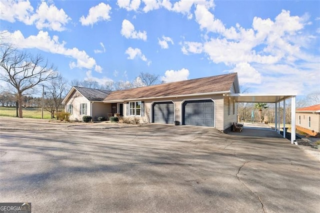 view of front of property featuring a garage, an attached carport, and driveway