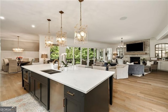 9370 Raldon Rd, Gainesville, GA 30506 - kitchen featuring a chandelier, open floor plan, light countertops, a fireplace, and light wood-style flooring