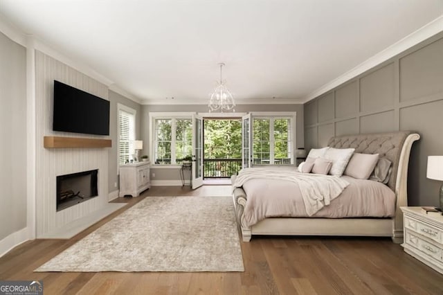 9370 Raldon Rd, Gainesville, GA 30506 - bedroom featuring a decorative wall, crown molding, a chandelier, a large fireplace, and access to exterior