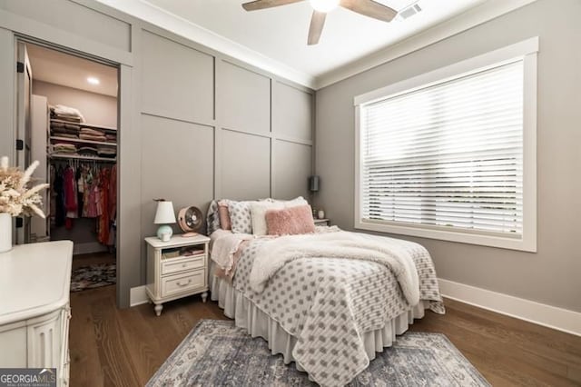9370 Raldon Rd, Gainesville, GA 30506 - bedroom with a walk in closet, dark wood finished floors, a closet, ceiling fan, and crown molding