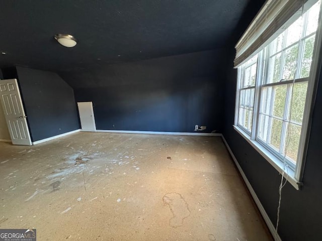 additional living space featuring vaulted ceiling and baseboards