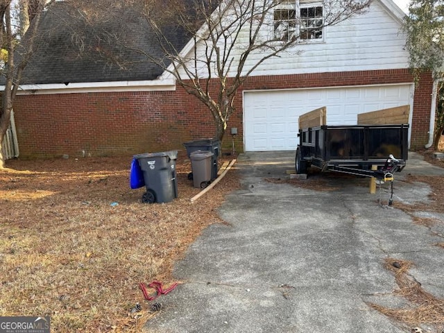 view of property exterior featuring aphalt driveway, brick siding, and a garage