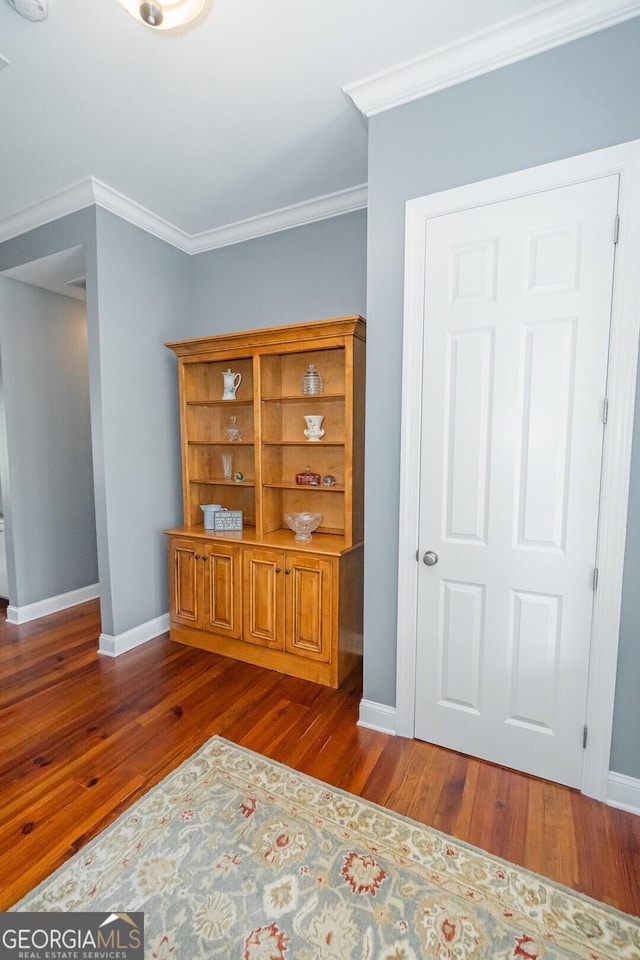 sitting room with ornamental molding, dark wood finished floors, and baseboards